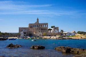an old building in the middle of a body of water at Dimora Del Mar in Polignano a Mare