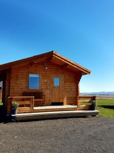 Cabaña de madera con porche en un campo en Guesthouse Didi en Flagbjarnarholt