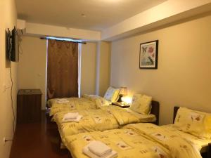 two beds in a room with yellow sheets at Hotel Prestige Struga in Struga