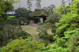 un jardín con una casa con techo de hierba en Funaya, en Matsuyama