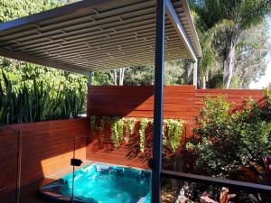 a hot tub in a patio with a wooden fence at Beach Cottage on Cassia Avenue, Central Coolum Beach in Coolum Beach