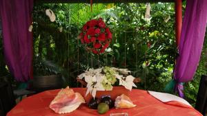 a red table with a plate of food and flowers at Posada Nativa Licy in San Andrés