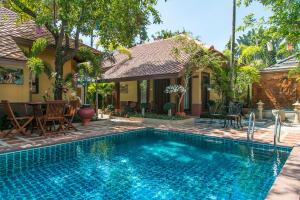 a swimming pool in front of a house at West Key Kamala Villa in Kamala Beach