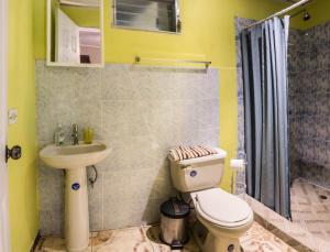 La salle de bains est pourvue de toilettes et d'un lavabo. dans l'établissement Agaseke Lodge Boquete, à Boquete