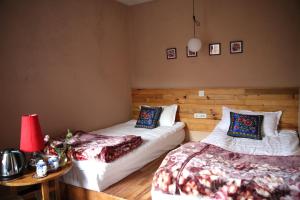 a bedroom with two beds and a table with a lamp at Flowers Residence in Yuanyang