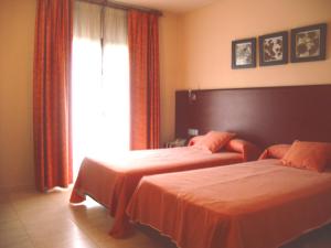 a bedroom with two beds and a window at Hotel Sant Quirze De Besora in Sant Quirze de Besora