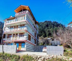 a tall building with a white at Ride At Hills-Nihal Cottage Manali in Manāli