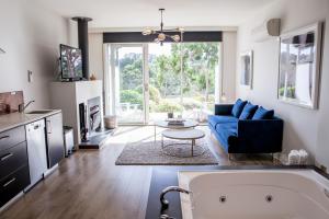 uma sala de estar com um sofá azul e uma mesa em Polperro Villas em Red Hill