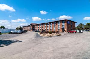 a large brick building with cars parked in a parking lot at Motel 6-Naperville, IL in Naperville