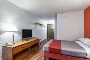 內珀維爾的住宿－內珀維爾6號汽車旅館，一间卧室配有一张床和一张书桌上的电视