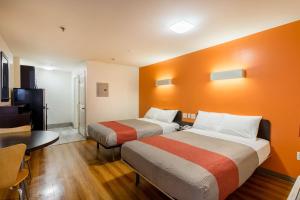 2 camas en una habitación de hotel con paredes de color naranja en Motel 6-Greenville, SC, en Greenville