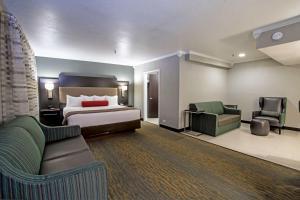 a hotel room with a bed and a couch and chairs at Best Western at O'Hare in Rosemont
