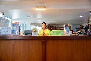 a woman behind the counter of a restaurant at Pranee Amata in Ko Tao