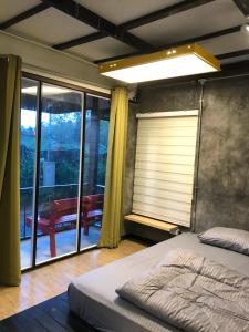 a bedroom with a bed and a large window at Sida Homemade in Chiang Khan