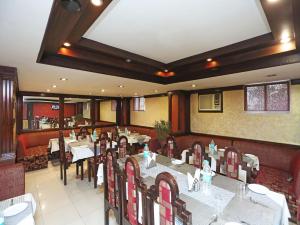 a restaurant with tables and chairs in a room at Hotel Amrit Regency in Guwahati