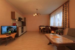 a living room with a television and a dining room at Ferienwohnungen Eckwirt Region: Klopeinersee-Turnersee in Sankt Kanzian