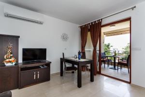 a living room with a dining room table and a television at Villa Aria in Malinska