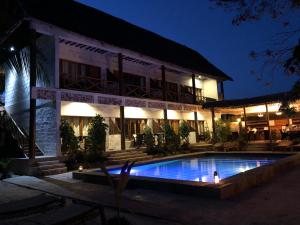 un hôtel avec une piscine en face d'un bâtiment dans l'établissement Tamani Villas - Annex, à Matemwe