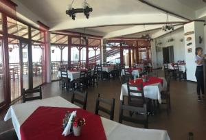 un restaurante con mesas y sillas rojas y blancas en Rio Divino, en Murighiol