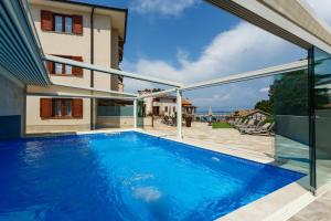 a swimming pool in the backyard of a house at Villa Aria in Malinska
