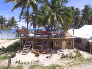 a small building on the beach with palm trees at SunnySide bed & bar in Siquijor