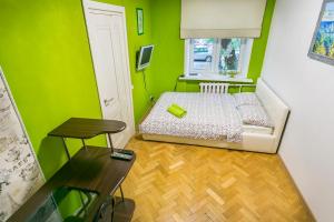 モスクワにあるАпартаменты на Малой Пироговской 6/4の緑豊かな小さなベッドルーム(ベッド1台、テーブル付)