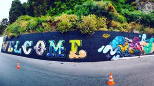 a wall with graffiti on the side of a road at Samaina Port Hotel in Karlovasi