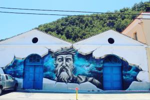 a mural of a man on the side of a building at Samaina Port Hotel in Karlovasi
