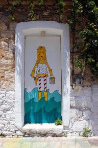 a picture of a woman painted on a wall at Samaina Port Hotel in Karlovasi