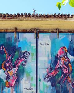 a painting of two octopus in a window at Samaina Port Hotel in Karlovasi
