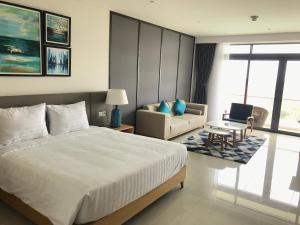 a bedroom with a bed and a couch and a chair at One Bedroom Apartment with Sea View in Danang