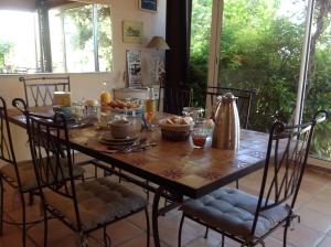 einem Esstisch mit Stühlen und einem Tisch mit Essen darauf in der Unterkunft jardin d'antan in Ansouis