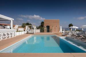 a swimming pool with a wooden deck and a swimming poolvisor at Residence Syracuse in Villeneuve-Loubet