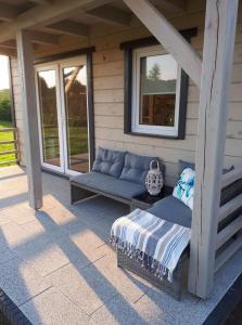 a porch with a blue couch on a patio at Ciche Wydmy in Sasino