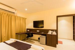 a hotel room with a desk and a television at LYNQ-CICO in Kolkata