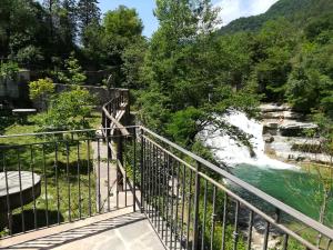 un ponte su un fiume con cascata di Mulino La Brusia a Portico di Romagna