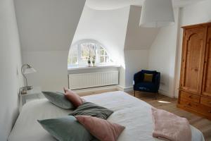 una camera da letto con un letto con cuscini sopra di Alter Konsumverein App N°9 a Westerland
