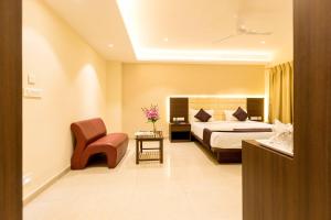 a hotel room with a bed and a chair at LYNQ-CICO in Kolkata