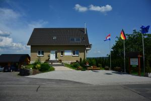 a house with a black roof and two flags at Gästehaus Celine in Meuspath