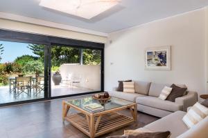 a living room with a couch and a table at Villa Ismini in Kato Daratso