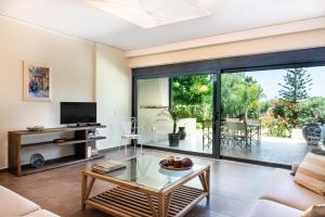 a living room with a couch and a table at Villa Ismini in Kato Daratso