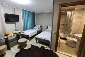 una camera d'albergo con due letti e un bagno di Hotel Shumak a Ulan-Ude Altre 92 foto