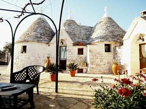 a house with a patio with a chair and a table at Trullo Sereno Angelo in Locorotondo