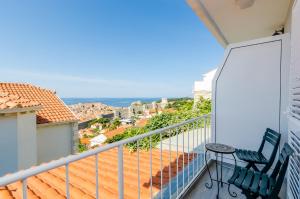 a balcony with two chairs and a view of the ocean at Apartments A&M in Dubrovnik