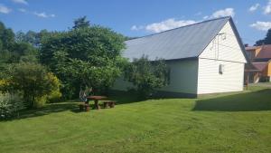 a white barn with a picnic table in the yard at U Jędrusia in Polańczyk