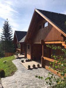 a large wooden house with a stone path in front of it at Glückliche Elfen in Sankt Kathrein am Hauenstein