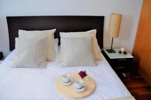 a tray with two mugs and two cups on a bed at Apartamento Torre1 in Santa Cruz de Tenerife