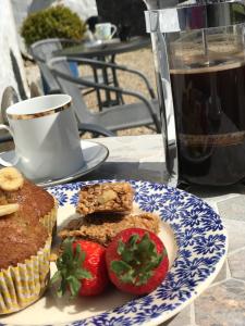 un plato de comida con una taza de café y fresas en Crofthead Farm House, en Tarbolton