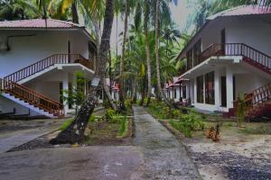 a street in front of a building with palm trees at Crossbill Beach Resort in Havelock Island