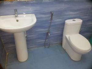 een badkamer met een wit toilet en een wastafel bij Crossbill Beach Resort in Havelock Island